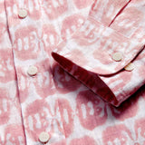 Close-up of a pink and white linen long sleeve shirt with button details, featuring a block-printed design of mirrored Asian elephants.