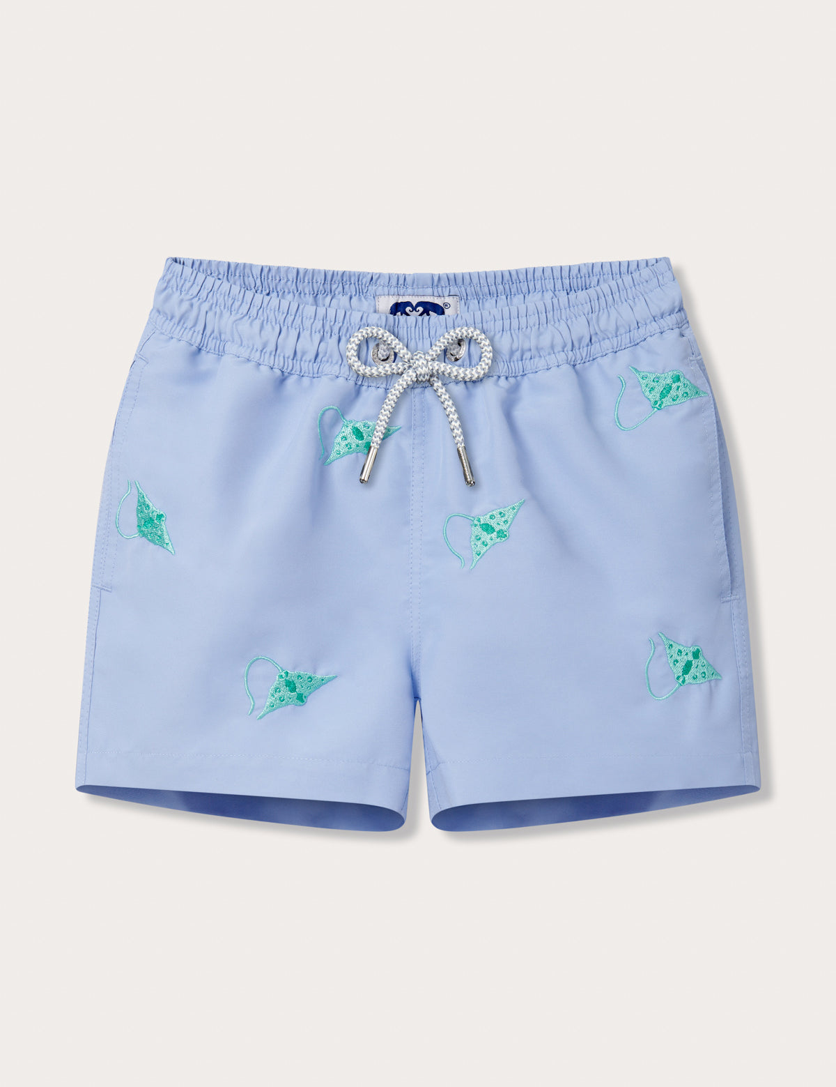 Light blue kids swim shorts with turquoise embroidered manta rays and a drawstring waistband.