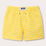 Yellow boys' swim shorts with a turtle print design inspired by SJ Villas' Caribbean properties, emphasizing turtle conservation.