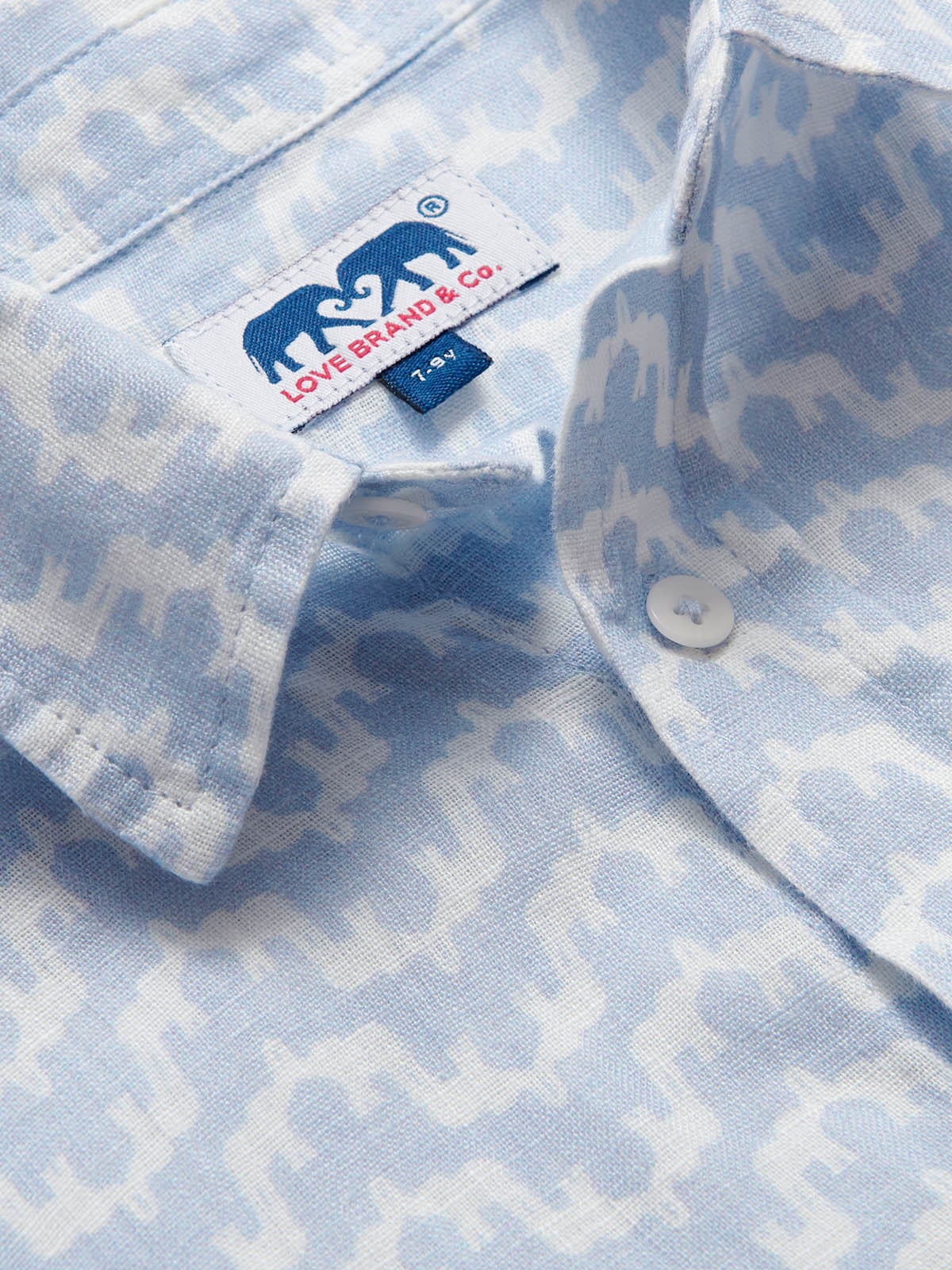 Close-up view of the Boys Elephant Palace Sky Abaco Linen Shirt showcasing the detailed elephant and Indian palace print, highlighting the button and brand label.