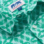 Close-up of Boys Palm Eagle Abaco Linen Shirt showcasing green tropical palm leaves and eagles design with brand label and buttons.