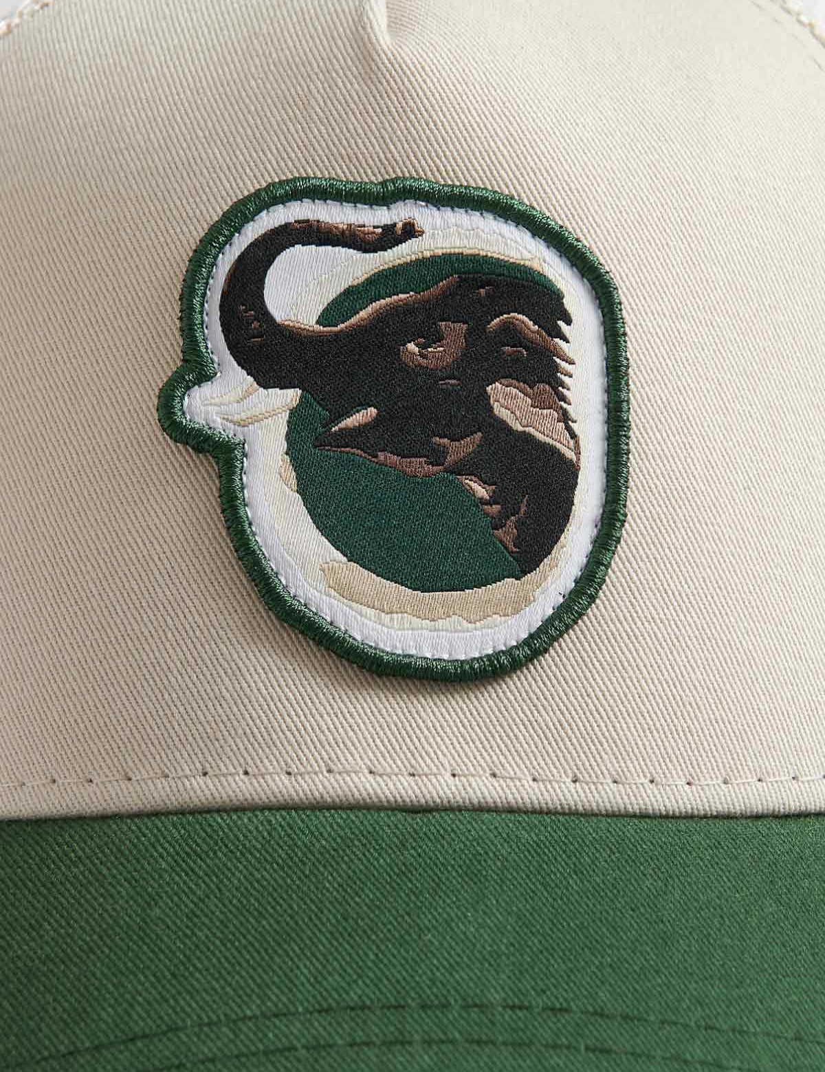 Close-up view of the front panel of the "Trucker Cap - Asian Elephant Trunk Up" featuring a detailed Indian Truck art design of an Asian elephant on a stone cotton twill crown with a forest green visor.