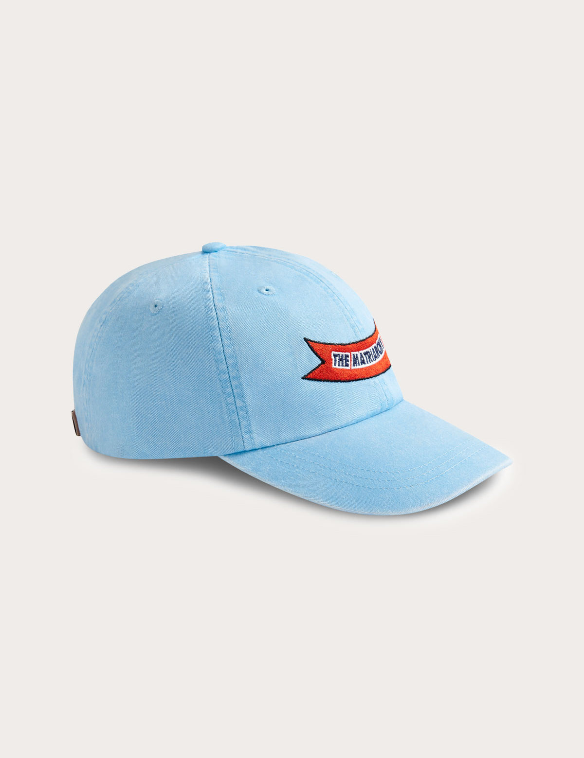 Sky blue cotton peak cap featuring 'The Matriarchy' ribbon embroidery on the front.