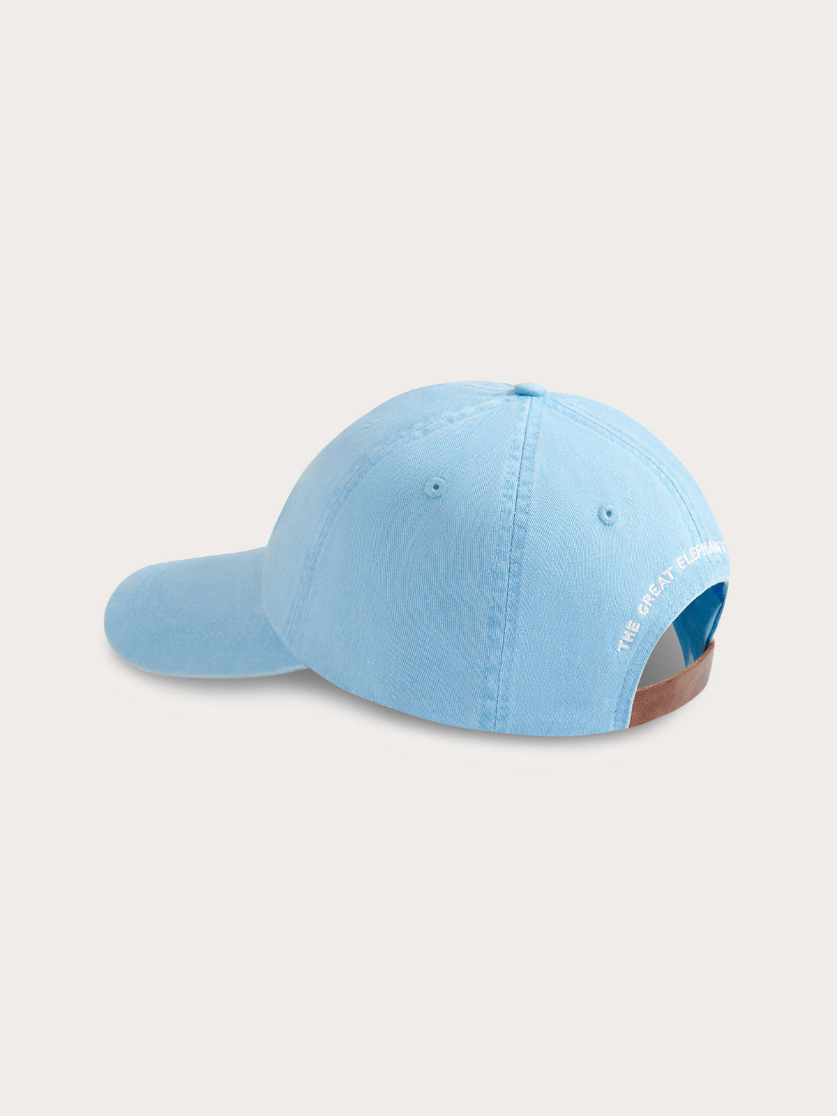 Sky blue cotton peak cap with 'The Great Elephant Migration' embroidery on the reverse and adjustable leather strap.