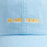 Sky blue cotton peak cap with 'We Are Family' embroidery on the front.