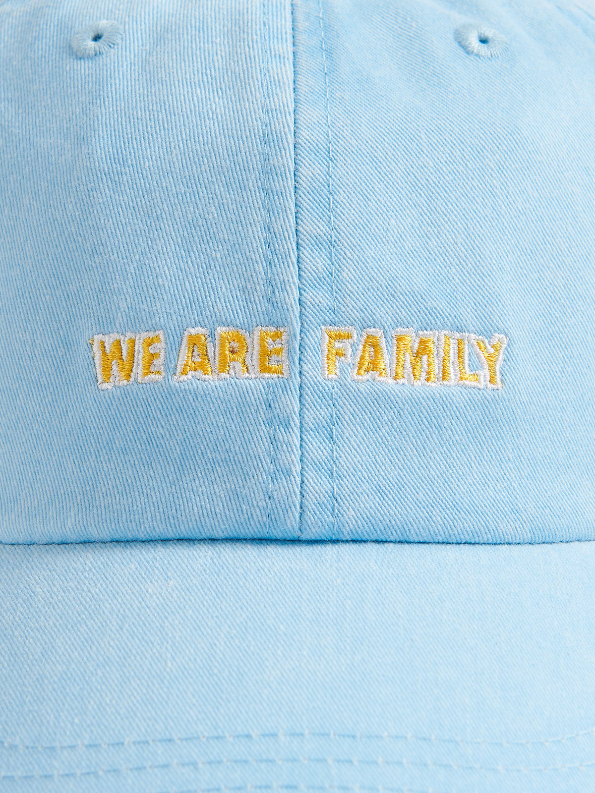 Sky blue cotton peak cap with 'We Are Family' embroidery on the front.