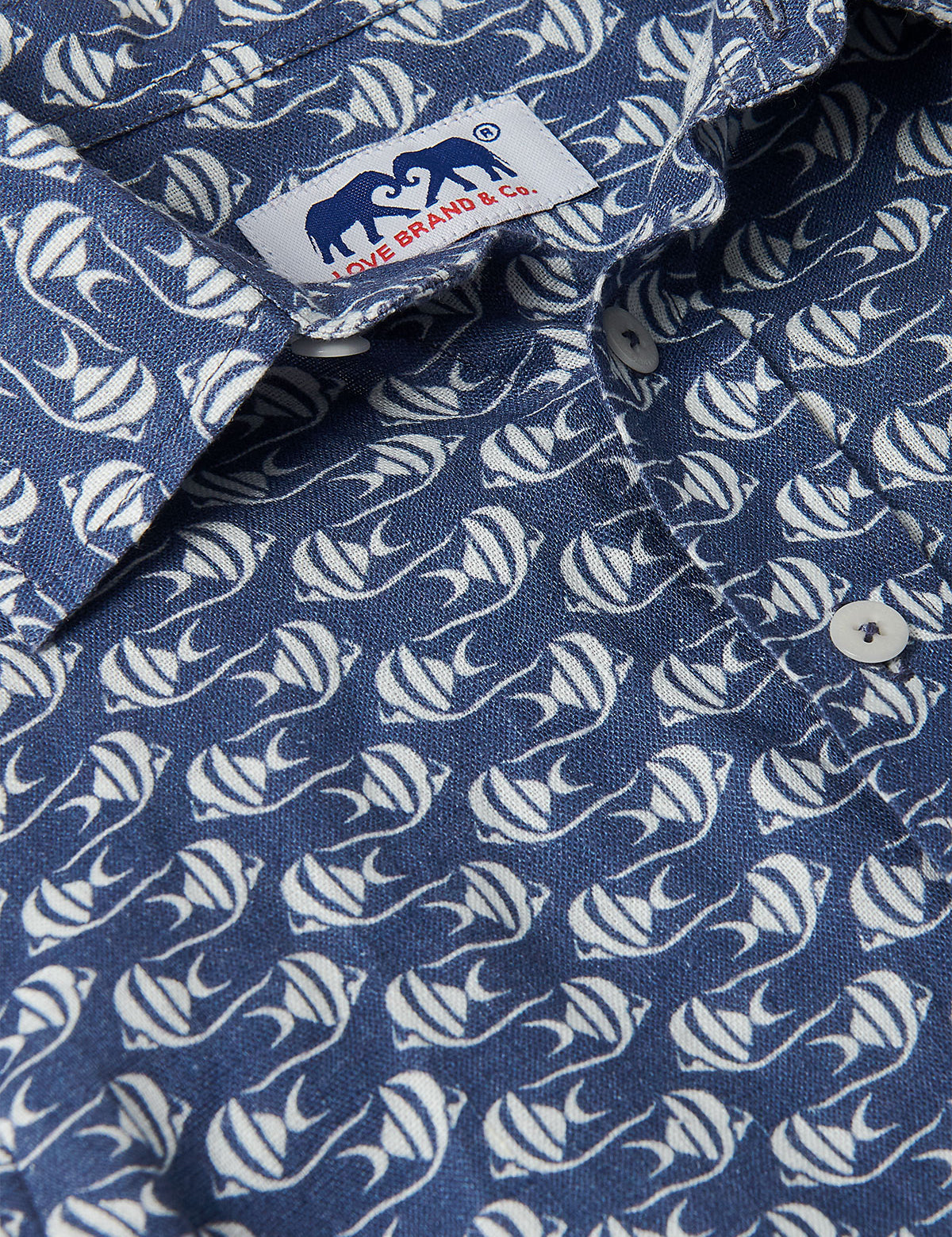 Close-up view of the Boys Go With the Flow Abaco Linen Shirt, featuring a pattern of Moorish Idol fish on a deep blue background.