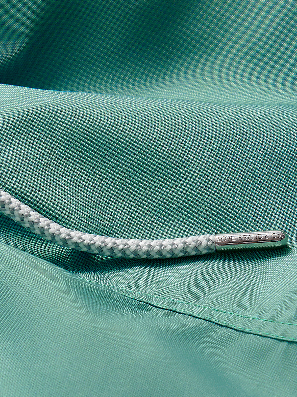 Close-up view of Boys Riviera Green Staniel Swim Shorts detailing quick-dry fabric and drawstring.