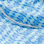 Close-up view of Boys Camel Mirage Sky Staniel Swim Shorts with a blue and white mirage pattern, highlighting the bespoke design celebrating Cop28 in Dubai 2023.