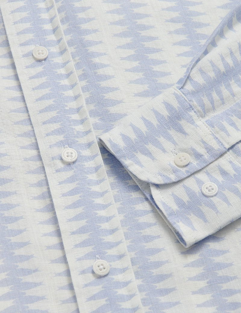 Close-up of Dishy Fishy Abaco men's Linen Shirt, featuring a serene blue and white fish pattern with white buttons, crafted from breathable 100% linen.