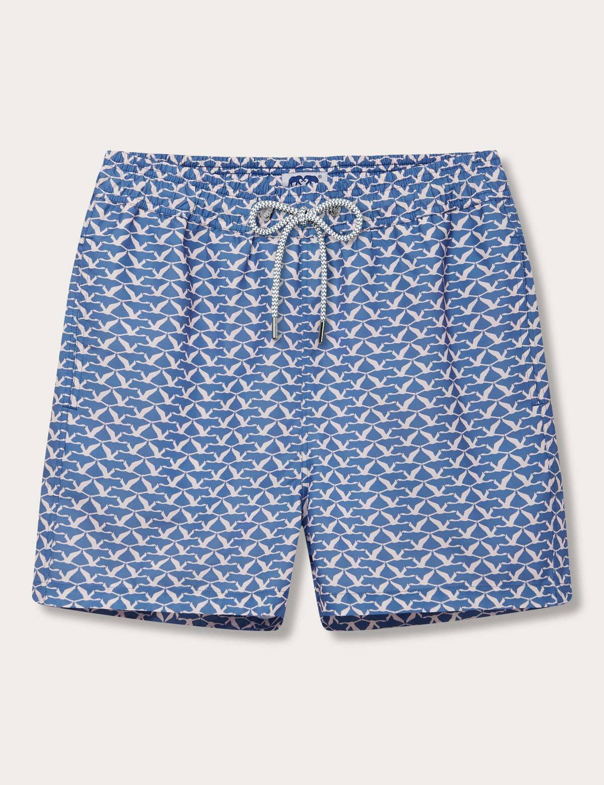 Mens swim shorts Flamingo Flamboyance featuring a pastel print flamingo pattern on a blue background.