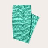 green linen trousers mens, featuring a pattern inspired by the Lesser Fish Eagle of India and tropical palms. mens linen trousers displayed on a light background.