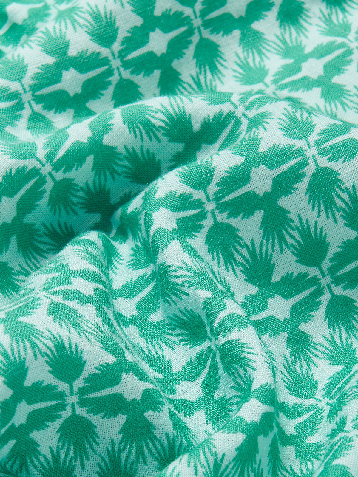 Close-up view of the green and white tropical palm and eagle pattern on the Men's Palm Eagle Joulter Linen Shorts.