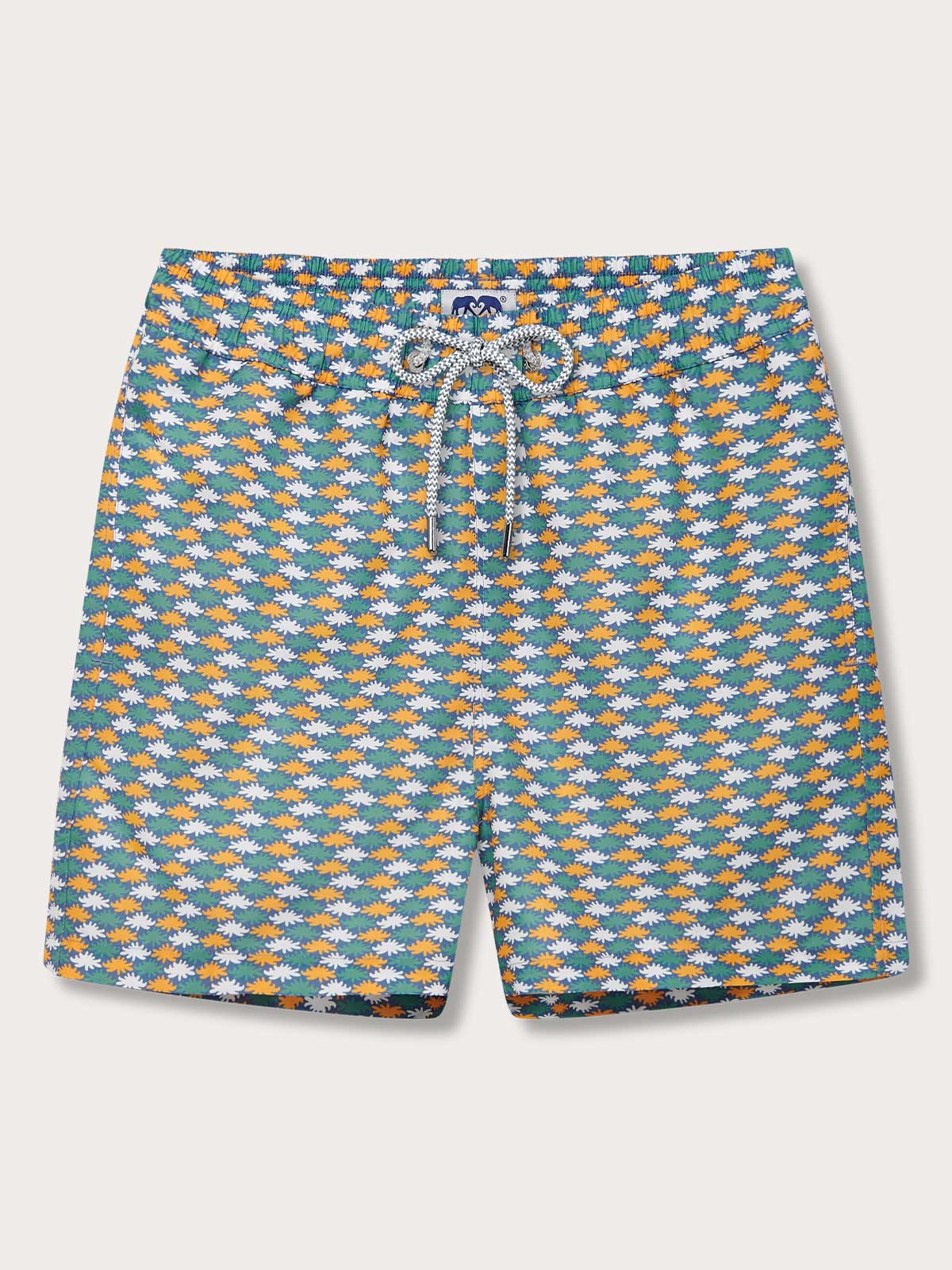 Men's Sea Flowers Staniel Swim Shorts with ochre, white, and green sea anemone pattern on a deep blue background.