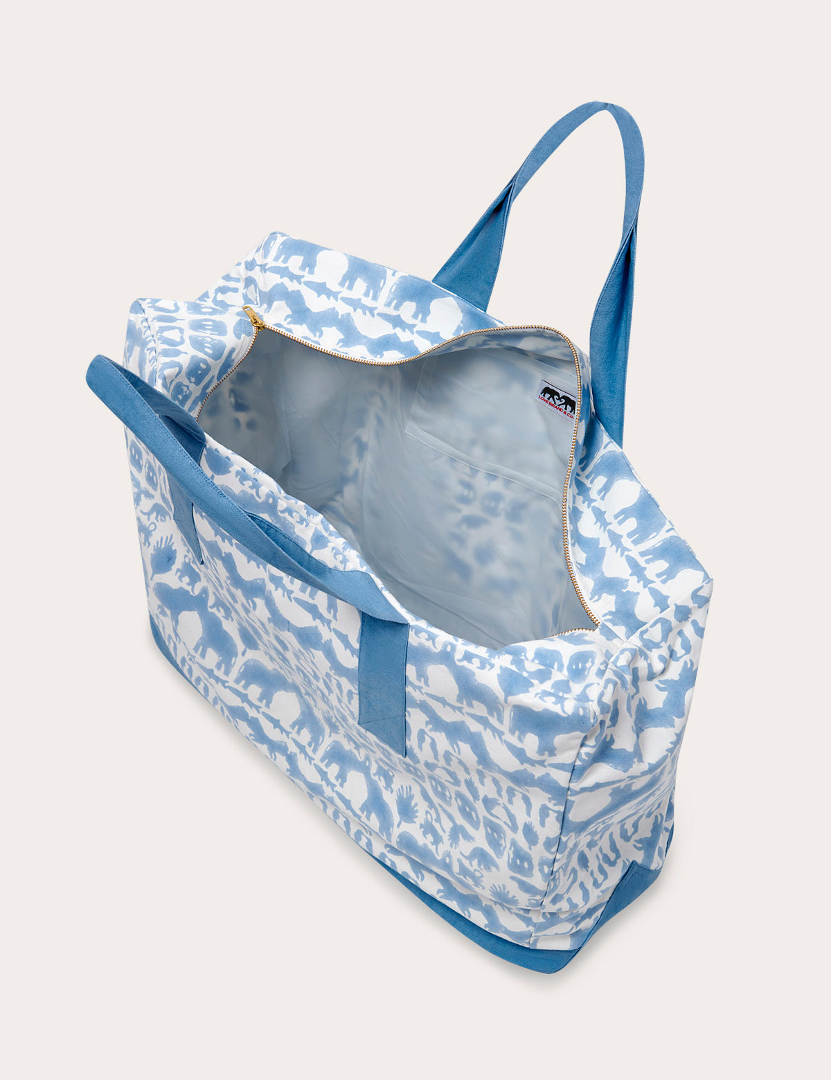 Sky blue canvas tote bag featuring Coexist animal print, open view showing interior pockets, and blue straps.